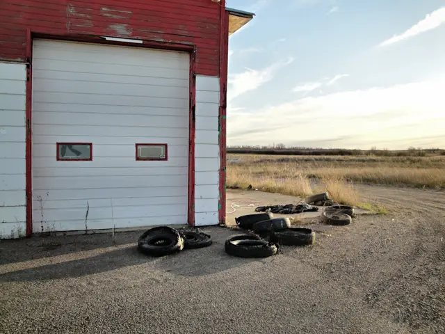 Old garage with discarded tires on the prairie